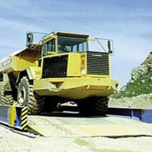 Truck on a Portable Weighbridge with safety barriers on both sides for weight measurement.